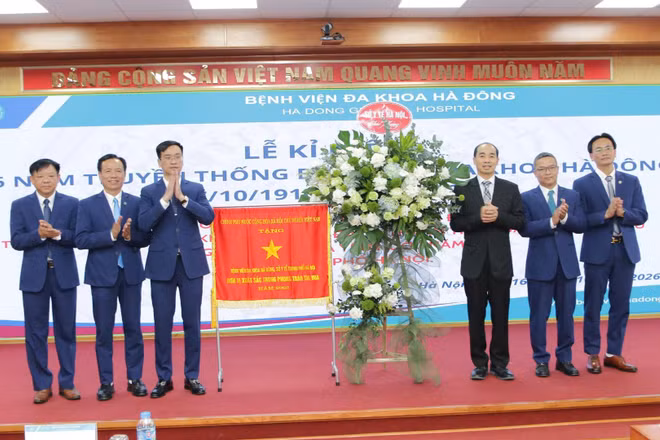 Thừa ủy quyền của Thủ tướng Chính phủ, Tiến sĩ, bác sĩ Nguyễn Đình Hưng, Phó Giám đốc Sở Y tế Hà Nội trao Cờ thi đua của Chính phủ cho lãnh đạo Bệnh viện đa khoa Hà Đông tại Lễ kỷ niệm. (Ảnh: VĂN LẬP)