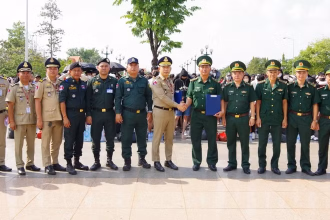 Lực lượng chức năng Campuchia và Đồn biên phòng cửa khẩu quốc tế Hoa Lư ký biên bản bàn giao công dân Việt Nam tại cột mốc 69. (Ảnh: TTXVN)
