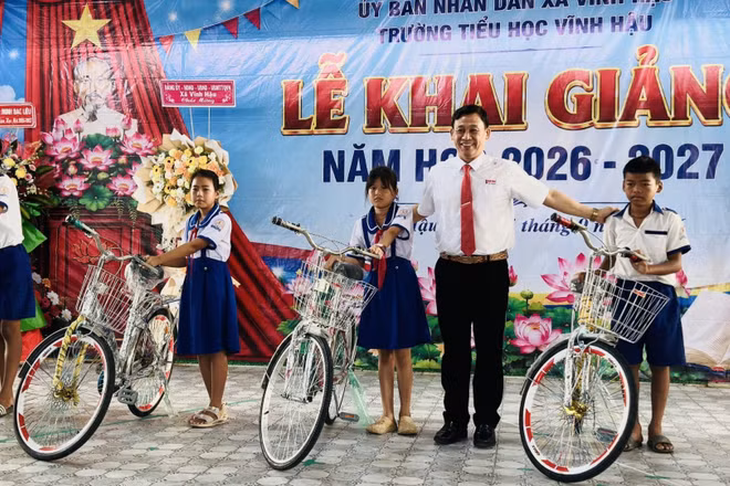 Đồng chí Trần Hoàng Khải, Chủ tịch Ủy ban nhân dân xã Vĩnh Hậu (Cà Mau), trao tặng xe đạp cho các em học sinh nghèo vùng ven biển, học sinh dân tộc Khmer trong xã. (Ảnh: ĐẶNG THẾ VĨNH)