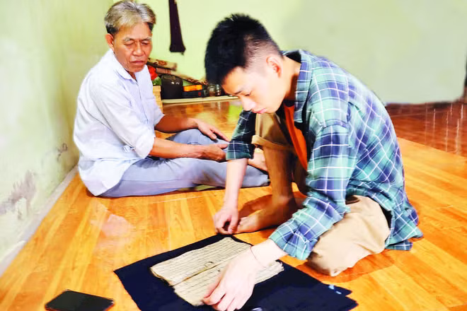 Sầm Công Danh (bên phải) tìm kiếm tư liệu trong cộng đồng.