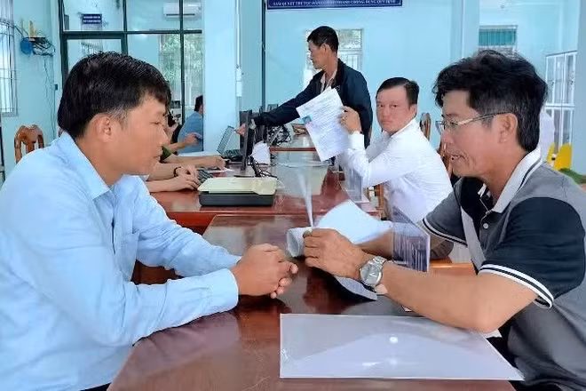 Cán bộ xã Đất Mũi (Cà Mau) hướng dẫn người dân thực hiện các thủ tục hành chính.