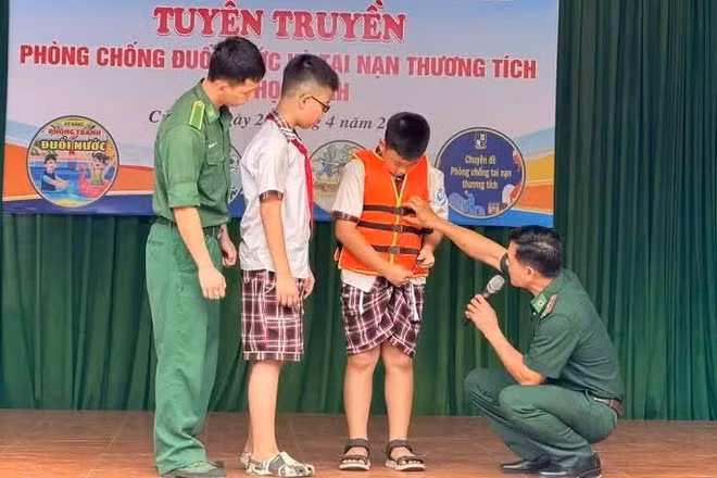Các cán bộ, chiến sĩ Đồn Biên phòng cửa khẩu cảng Cửa Lò-Bến Thủy hướng dẫn các em học sinh sử dụng áo phao đúng cách.
