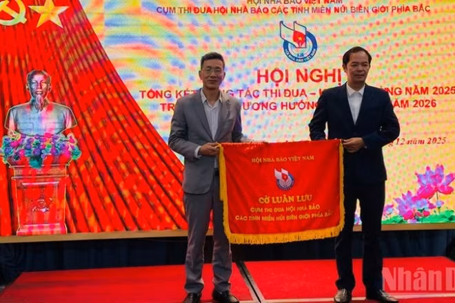 Hội Nhà báo tỉnh Lào Cai và Cao Bằng trao cờ thi đua tại hội nghị. (Ảnh: THANH SƠN)
