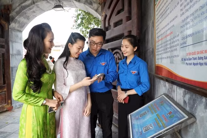 Đoàn viên, thanh niên tỉnh Bắc Giang hướng dẫn người dân quét mã QR khi đến tham quan Khu di tích chiến thắng Xương Giang. (Ảnh: DANH LAM)