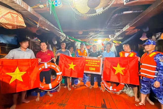 Cảnh sát biển trao quà tặng tàu cá ngư dân.