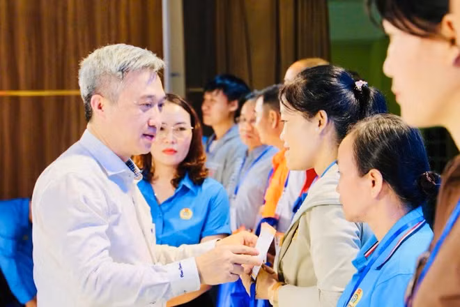 Đồng chí Đặng Minh Thông, Phó Bí thư Thành ủy Thành phố Hồ Chí Minh trao quà cho người lao động có hoàn cảnh khó khăn. 
