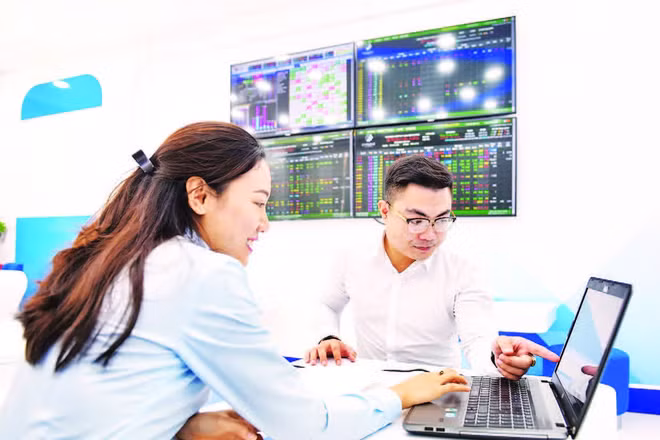 Nhà đầu tư theo dõi hoạt động của thị trường chứng khoán (Ảnh: TUỆ NGHI)