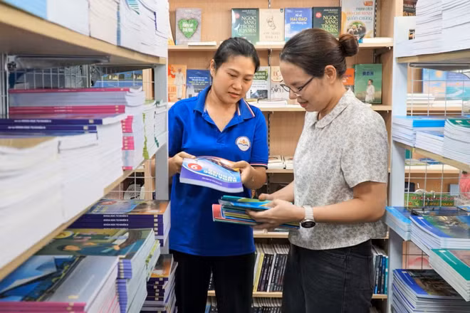 Phụ huynh mua sách giáo khoa chuẩn bị cho năm học mới. (Ảnh: HỒ LÀI)