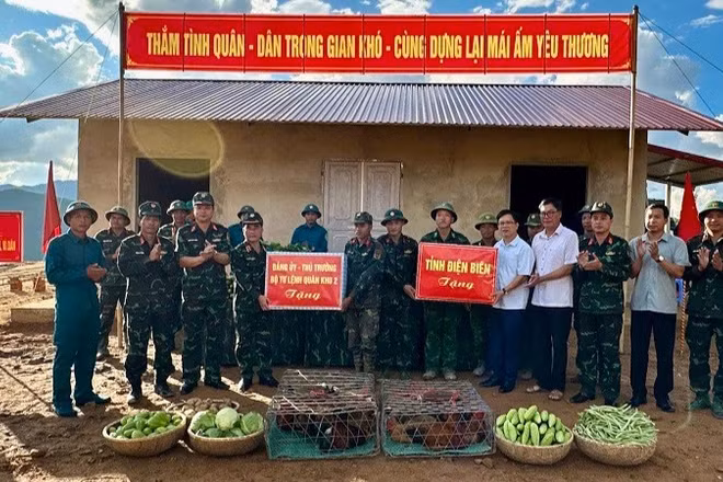 Thiếu tướng Nguyễn Đăng Khải và đồng chí Phạm Đức Toàn, Phó Chủ tịch Ủy ban nhân dân tỉnh Điện Biên trao quà, động viên các cán bộ, chiến sĩ đang giúp nhân dân làm nhà ở mới tại điểm tái định cư bản Háng Pù Xi, xã Xa Dung. (Ảnh: ĐỨC HẠNH)