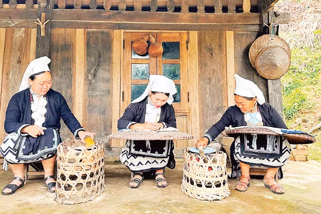 Các nghệ nhân ở bản Hoài Khao (Cao Bằng) thực hiện kỹ thuật thêu và in hoa văn bằng sáp ong.