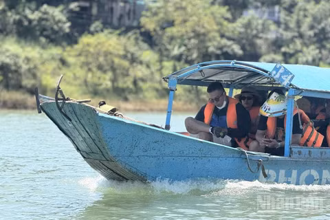 Khách du lịch trải nghiệm dịch vụ tàu vào hang động Phong Nha-Kẻ Bàng, Quảng Trị. (Ảnh: HNV)