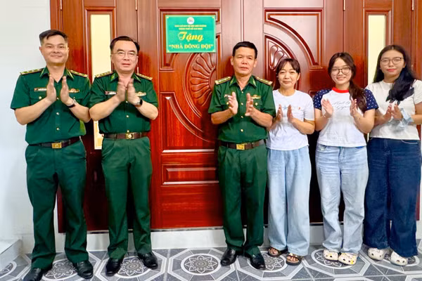 Trung tá Đồng Quang Linh (thứ tư từ phải sang) nhận bàn giao Nhà đồng đội. (Ảnh: QUANG ANH)