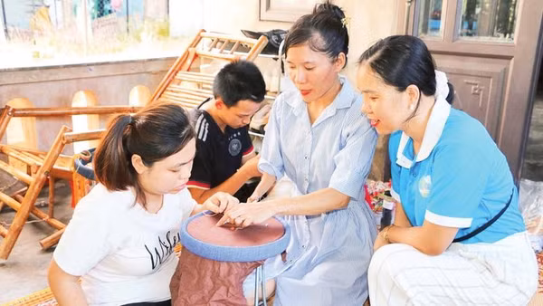 Chị Nguyễn Thị Hà (thứ hai, từ phải sang) hướng dẫn học viên khuyết tật thêu tranh.