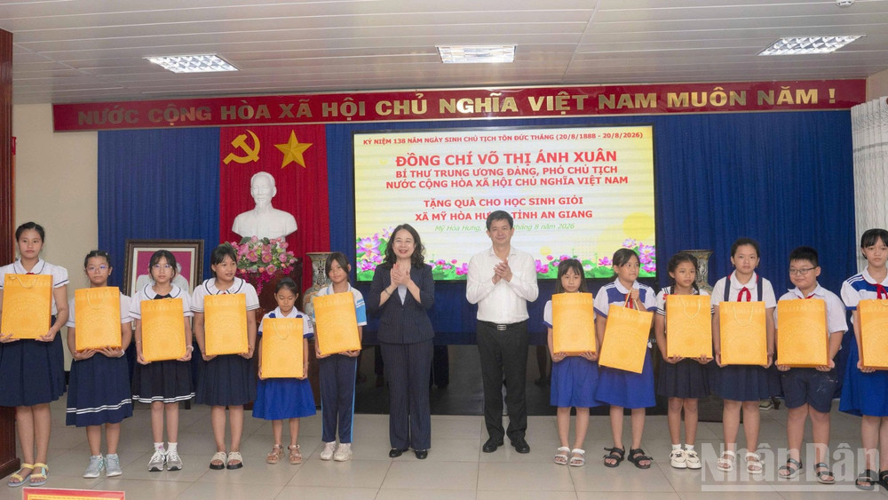 Đồng chí Võ Thị Ánh Xuân và đồng chí Lê Quang Tùng tặng quà cho học sinh xã Mỹ Hòa Hưng. (Ảnh: Thanh Dũng)