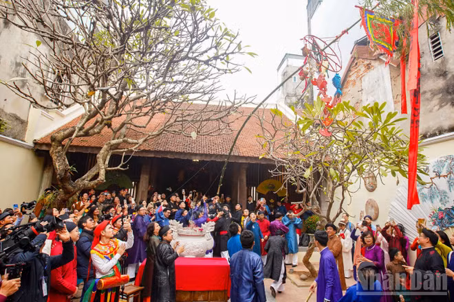 Du khách thích thú khi được chứng kiến nghi thức dựng nêu ngày Tết tại đình Kim Ngân vào dịp Tết 2025. (Ảnh: THẾ ĐẠI)