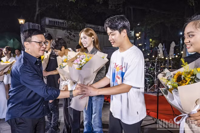Tổng Biên tập Báo Nhân Dân Lê Quốc Minh tặng hoa cho các ca sĩ biểu diễn tại chương trình. (Ảnh: THÀNH ĐẠT)