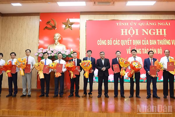 Đồng chí Hồ Văn Niên, Ủy viên Trung ương Đảng, Bí thư Tỉnh ủy Quảng Ngãi trao quyết định và tặng hoa chúc mừng 11 cán bộ chủ chốt được luân chuyển, điều động nhận nhiệm vụ mới. 