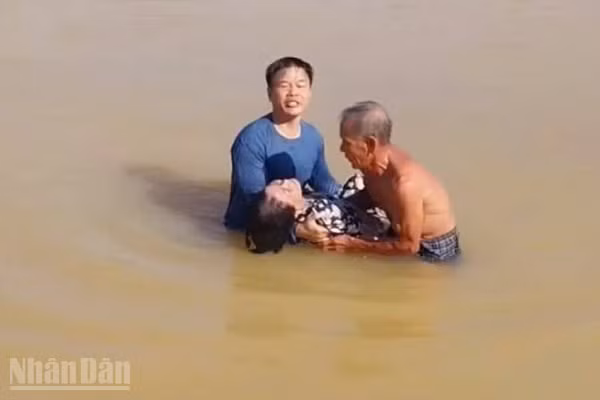 Thượng tá Lê Diệt cùng người dân cứu bà TTL trên sông Hương sáng 2/10. (Ảnh: Q.T)