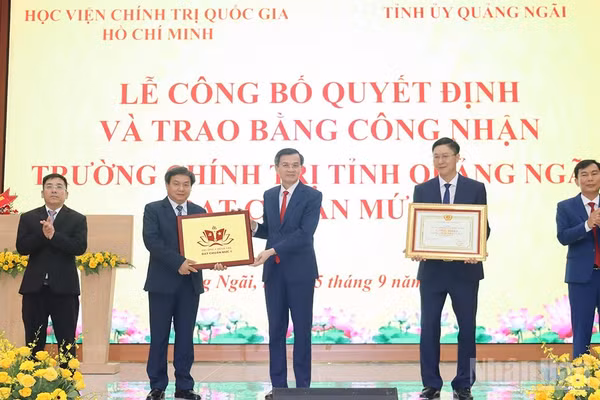 Phó Giáo sư, Tiến sĩ Đoàn Minh Huấn, Ủy viên Bộ Chính trị, Giám đốc Học viện Chính trị quốc gia Hồ Chí Minh trao Bằng công nhận đạt chuẩn mức 1 cho Trường chính trị tỉnh Quảng Ngãi. (Ảnh: HIỂN CỪ)