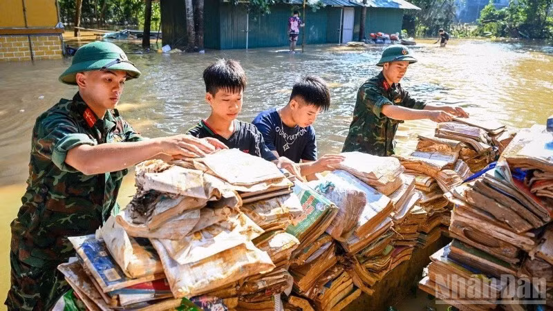Bộ đội và học sinh đưa sách vở lên phơi trên nơi khô ráo tại Trường phổ thông dân tộc nội trú trung học cơ sở và trung học phổ thông Hữu Lũng, tỉnh Lạng Sơn trong đợt lũ lịch sử 2025 tại địa bàn. (Ảnh: THÀNH ĐẠT)