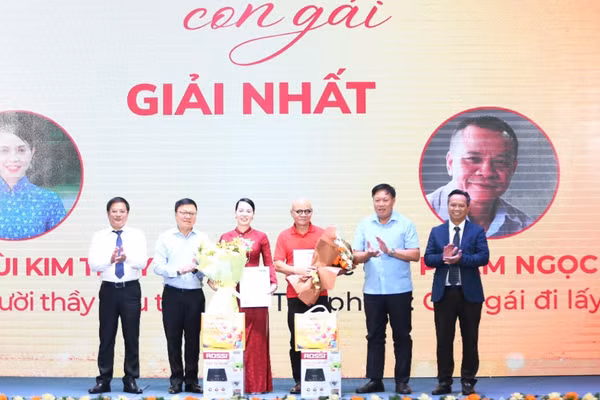 Nhà báo Lê Quốc Minh, Ủy viên Trung ương Đảng, Tổng Biên tập Báo Nhân Dân, Phó Trưởng Ban Tuyên giáo Trung ương, Chủ tịch Hội Nhà báo Việt Nam cùng đại diện Ban Tổ chức cuộc thi trao giải Nhất cho hai tác giả. (Ảnh: Ban Tổ chức)