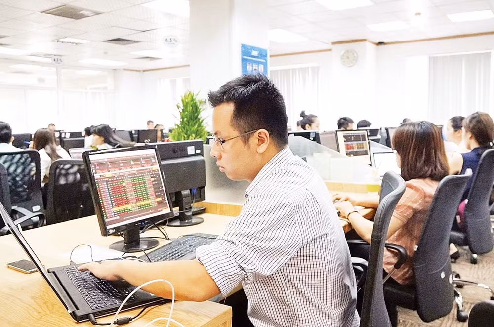 Nhà đầu tư theo dõi giao dịch trên thị trường chứng khoán. (Ảnh VIẾT CHUNG)