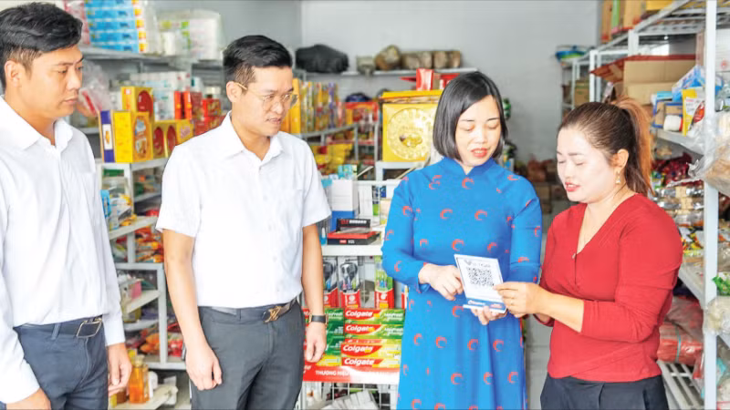 Các cán bộ của Co-opBank Phú Thọ hướng dẫn hộ kinh doanh tiếp cận dịch vụ số của ngân hàng.