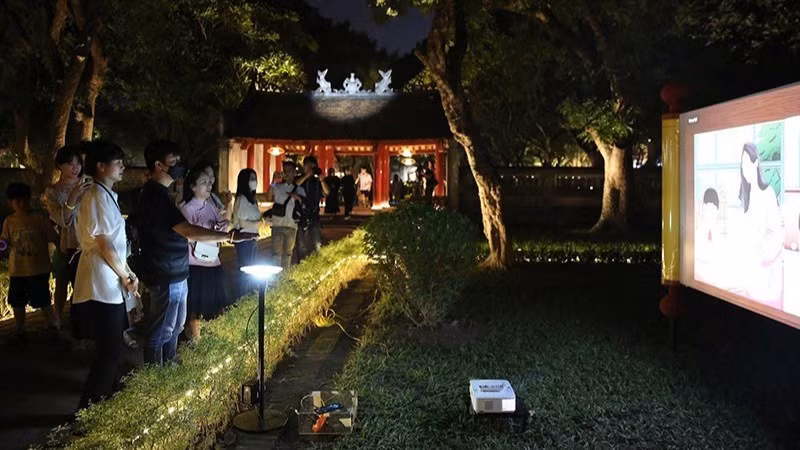 Du khách tham quan tour “Trải nghiệm đêm Văn Miếu-Quốc Tử Giám”. (Ảnh Thành Nguyễn)