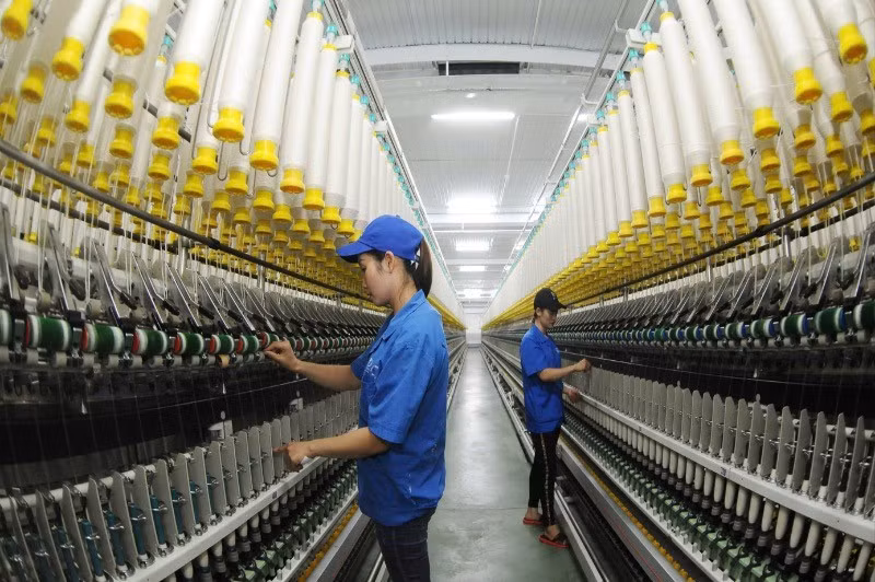 Công nhân Công ty TNHH một thành viên Dệt 8-3 vận hành dây chuyền sản xuất sợi. (Ảnh: TRẦN HẢI)