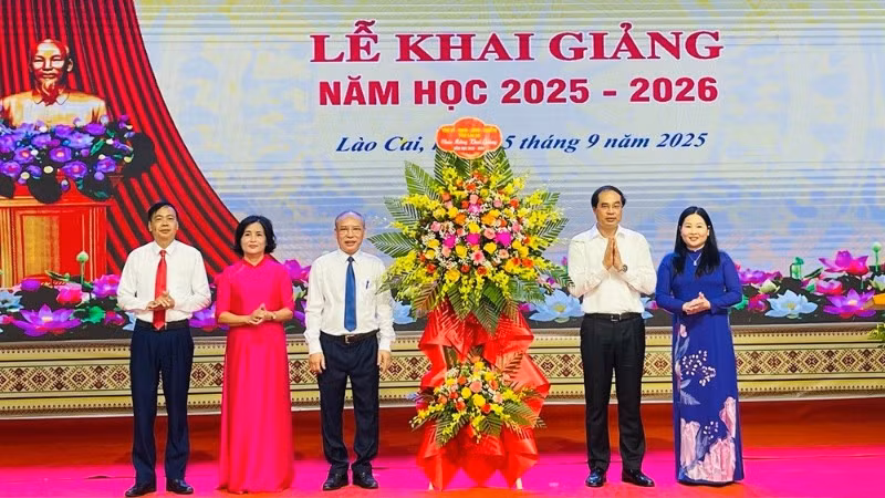 Bí thư Tỉnh ủy Trịnh Xuân Trường tặng hoa chúc mừng nhà trường. (Ảnh: THANH SƠN)