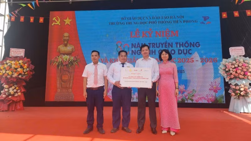 Đại diện Báo Nhân Dân trao biểu trưng 20 suất học bổng đến lãnh đạo Trường trung học phổ thông Tiền Phong. 