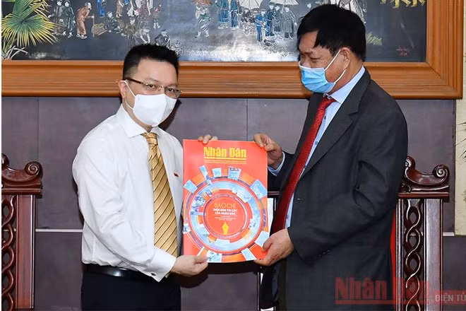 Đồng chí Lê Quốc Minh tặng đồng chí Huỳnh Tấn Việt (bên phải) số báo đặc biệt nhân ngày 21-6. (ẢNH: THỦY NGUYÊN)