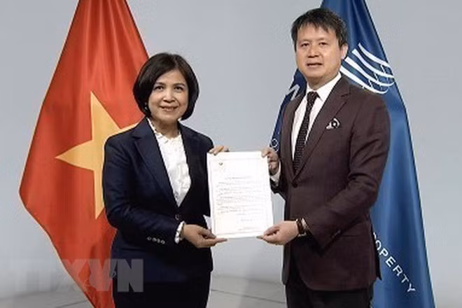 Đại sứ Lê Thị Tuyết Mai trao văn kiện Việt Nam gia nhập Hiệp ước WIPO về buổi biểu diễn và bản ghi âm cho Tổng giám đốc WIPO Daren Tang. (Ảnh: TTXVN)