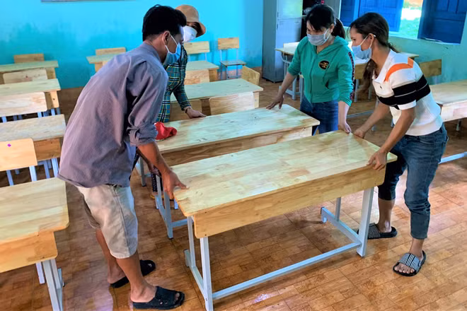 Giáo viên và phụ huynh Trường tiểu học Bùi Thị Xuân, xã vùng sâu Ea M’Droh, huyện Cư M’gar chuẩn bị bàn ghế đón học sinh đến trường học tập.
