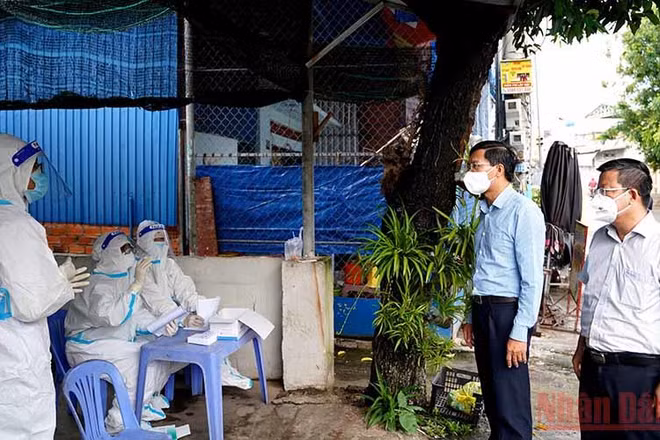 Chủ tịch UBND tỉnh Bình Thuận Lê Tuấn Phong (thứ hai, bên phải) kiểm tra một điểm lấy mẫu xét nghiệm SARS-CoV-2. (Ảnh: Hữu Tri)