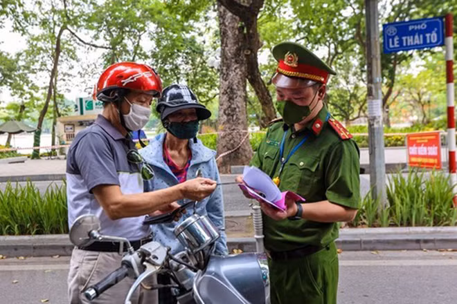 Lực lượng chức năng kiểm tra các phương tiện lưu thông trong thời gian giãn cách xã hội. (Ảnh: TTXVN)