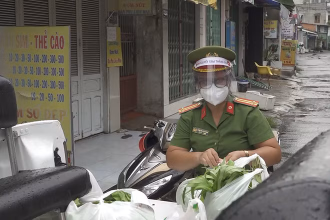 Nữ cảnh sát khu vực Đinh Thị Diệu Hạnh đi chợ giúp dân trong lúc thực hiện giãn cách xã hội.