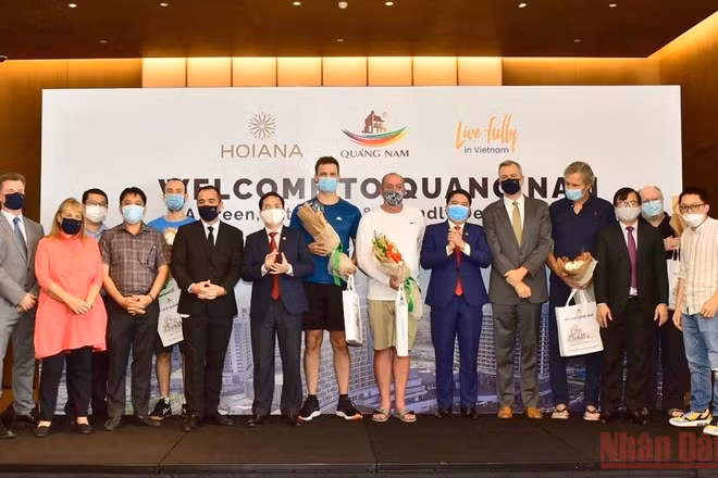 Phó Chủ tịch UBND tỉnh Quảng Nam Trần Văn Tân tặng hoa chúc mừng đại diện đoàn khách quốc tế đầu tiên đến Quảng Nam. (Ảnh: TẤN NGUYÊN)