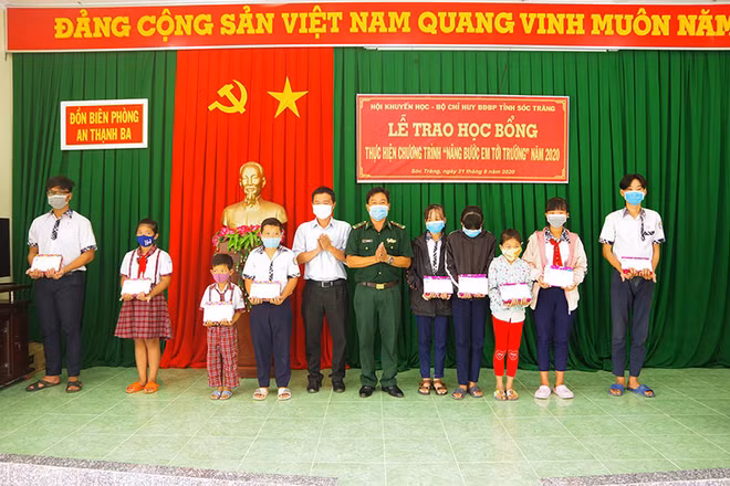 Đại diện Ban Chỉ huy Đồn Biên phòng An Thạnh Ba và lãnh đạo Chi nhánh Viettel Sóc Trăng trao học bổng cho các em học sinh. 