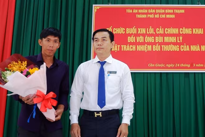 Phó Chánh án TAND quận Bình Thạnh (TP Hồ Chí Minh) Vũ Ngọc Hoan tặng hoa cho anh Lý.