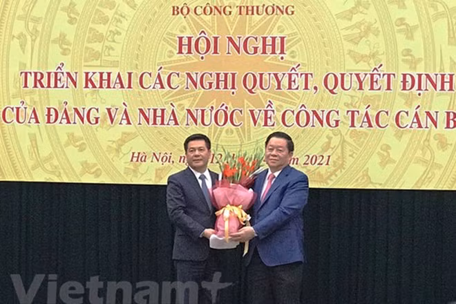 Bí thư Trung ương Đảng, Trưởng Ban Tuyên giáo Trung ương Nguyễn Trọng Nghĩa tặng hoa và chúc mừng tân Bộ trưởng Bộ Công thương Nguyễn Hồng Diên. (Ảnh: Vietnam+)