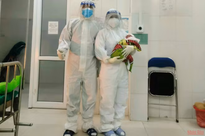 Các điều dưỡng viên chăm sóc trẻ sơ sinh, con của bệnh nhân Covid-19. 