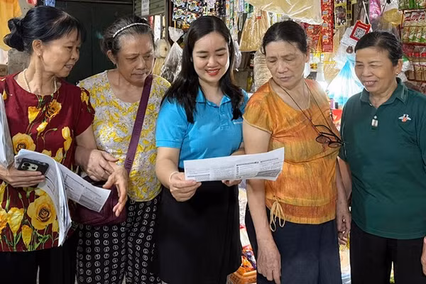 Cán bộ Bảo hiểm xã hội Hà Nội vận động người dân tham gia bảo hiểm xã hội tự nguyện, bảo hiểm y tế hộ gia đình. (Ảnh HSS)