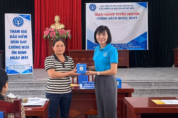 Cán bộ Bảo hiểm xã hội Hà Nội trao hỗ trợ chính sách an sinh xã hội cho người dân. (Ảnh: HSS)