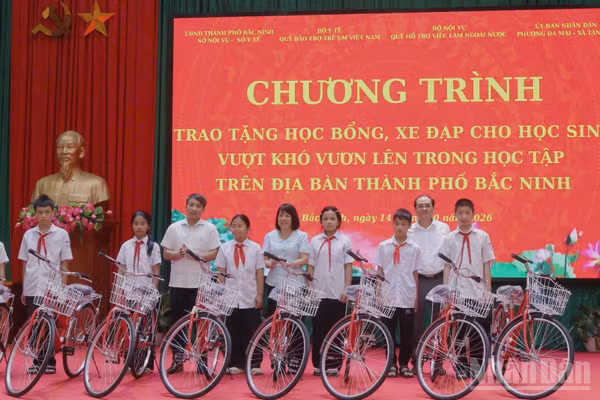 Các đại biểu trao tặng xe đạp cho các học sinh tại chương trình. (Ảnh NGÂN ANH)