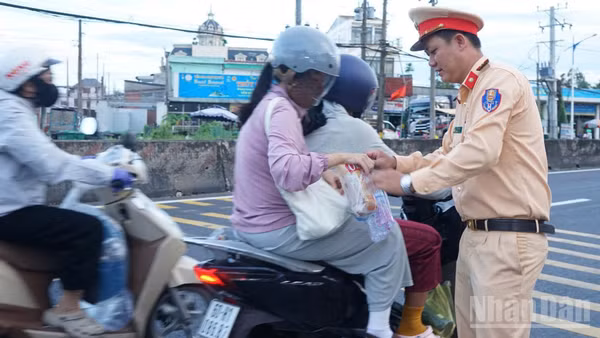 Lực lượng Cảnh sát giao thông (Công an tỉnh Đồng Tháp) tặng quà cho người dân về quê nghỉ lễ.