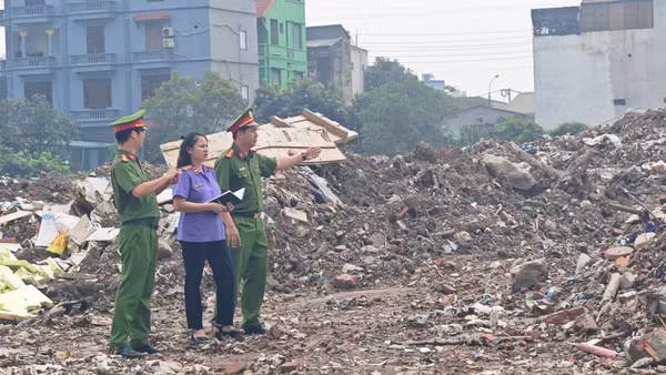 Lực lượng chức năng tại hiện trường, xác định diện tích và khối lượng chất thải xây dựng bị đổ trái phép. (Ảnh: Công an Hà Nội)