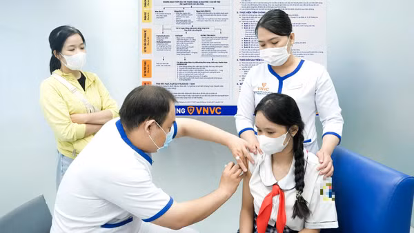 Phụ huynh cho trẻ đi tiêm vaccine phòng bệnh não mô cầu. Ảnh: VNVC