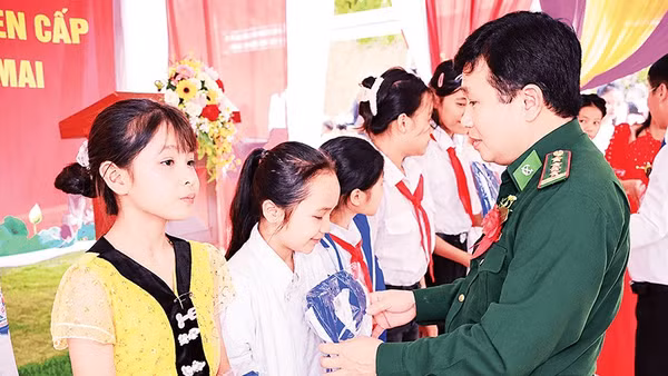Lãnh đạo Ban Chỉ huy Bộ đội Biên phòng tỉnh Nghệ An trao quà tặng các học sinh vùng biên. 