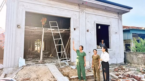 Ngôi nhà khang trang, kiên cố của bà Trần Thị Minh (áo xanh) ở thôn Thạch Mỹ, xã Mai Phụ đang dần được hoàn thiện. 